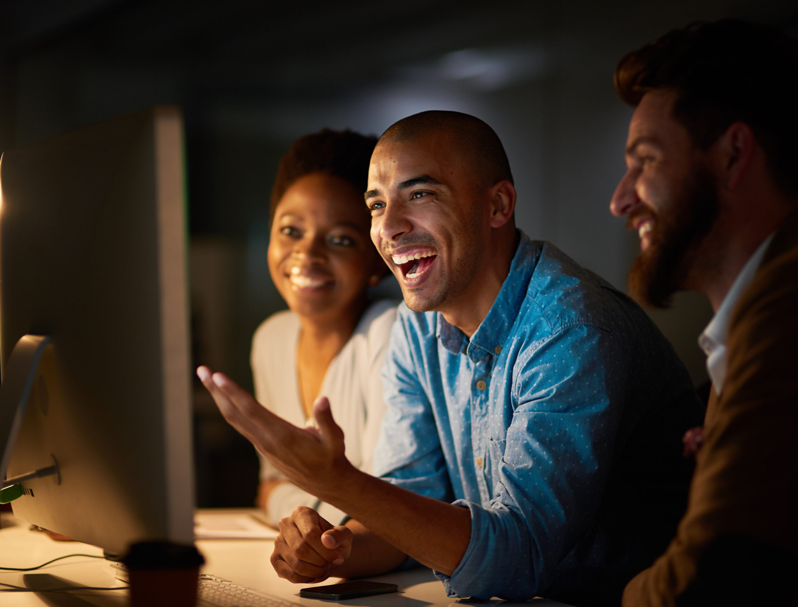 Laughing, meeting and business people in office at night for planning, teamwork and collaboration. Happy, creative agency and men and women on computer for online project, website and research.